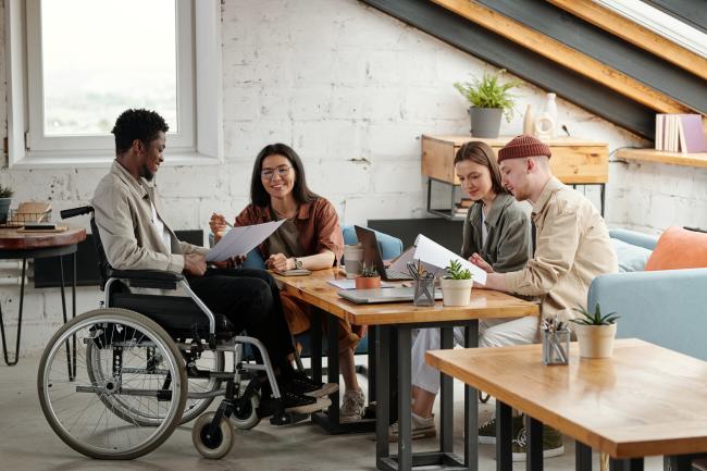 A group of people sitting around a table discussing some documents